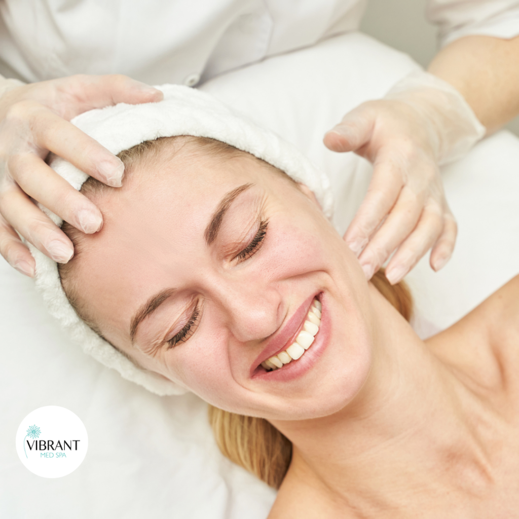 Woman-getting-facial-massage-smiling-vibrant-med-spa-roundrock